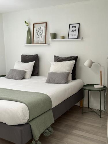 a bedroom with two beds and a lamp at La Villa Bis in Vesoul