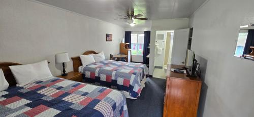 a hotel room with two beds and a tv at Myrtle Lane Inn in Coquille