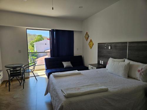 ein Schlafzimmer mit einem Bett, einer Couch und einem Tisch in der Unterkunft Casa Xtao Hotel in Santa Cruz Huatulco