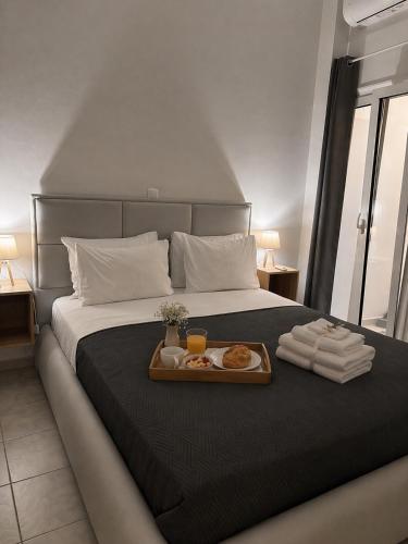 a bed with a tray of food on top of it at Emari Apartments in Heraklio