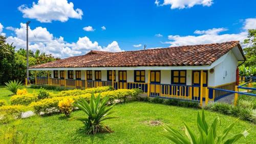 a house with a garden in front of it at Finca Hotel La Herencia Cafetera in Montenegro