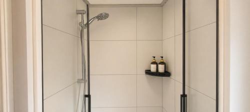a shower stall with two bottles of wine on a shelf at Boshuisje Dille te Veluwe in Putten