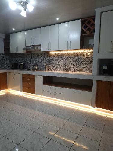 a kitchen with white cabinets and a tile floor at La Casa del Centro in Quesada
