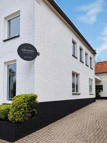 a white building with a sign on the side of it at Geuldal Guest Apartments in Valkenburg
