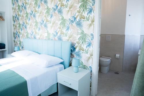 a bedroom with a bed with a blue and white wallpaper at Villa Rossa in Agerola