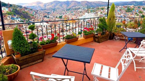 a balcony with a table and chairs and plants at Casa Rofo in Guanajuato