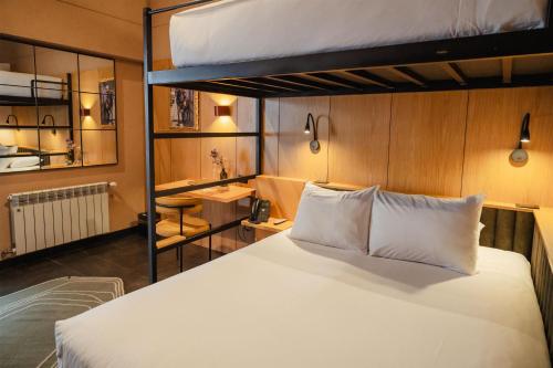 a bedroom with two bunk beds and a white bed at Motto By Hilton Cusco in Cusco