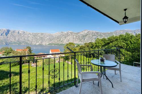 a balcony with a table and chairs and a view of the water at Horizon Apartments in Prčanj