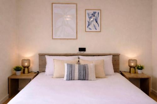 a bedroom with a large white bed with two lamps at Boshuisje Dille te Veluwe in Putten