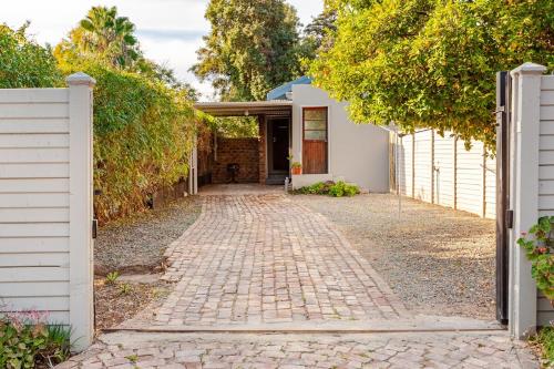 a brick walkway leading to a house at Self-catering Garden Cottage in Oudtshoorn
