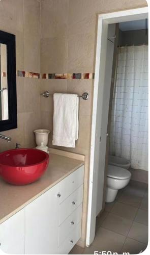 a bathroom with a red sink and a toilet at Casa refugio in Santa María