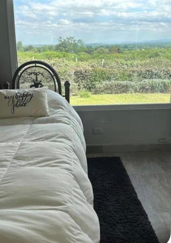 a bedroom with a bed and a window with a view at Casa refugio in Santa María