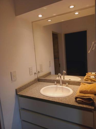 a bathroom with a sink and a large mirror at Bernal Alquileres in Viedma