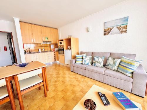 a living room with a couch and a kitchen at Sol e Piscina na Caparica - By Caparica Villas in Costa da Caparica