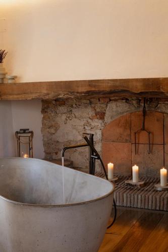 a bath tub sitting in a room with candles at Mas Escarrà in Caldes de Malavella