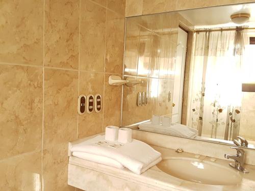 a bathroom with a sink and a mirror at Cordelius Hotel in Puno