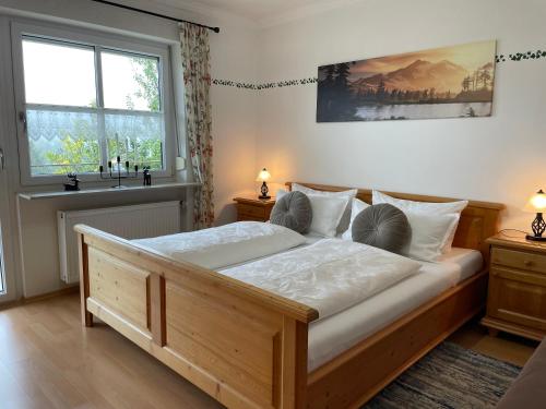 a bedroom with a large wooden bed with white sheets at Ferienhaus Heidi in Lam