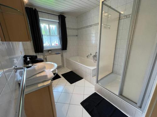 a bathroom with a shower and a sink and a tub at Ferienhaus Heidi in Lam