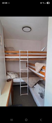 a room with two bunk beds and a desk at Appartement T1 Superdévoluy 6 personnes in Le Dévoluy