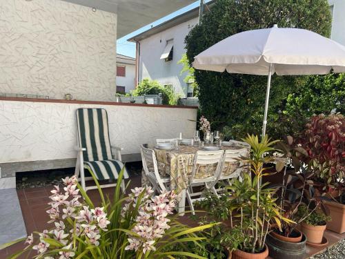 a table and chairs under an umbrella on a patio at Casa Nina in Marina di Massa