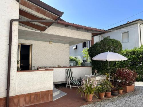 a patio with a table and an umbrella at Casa Nina in Marina di Massa