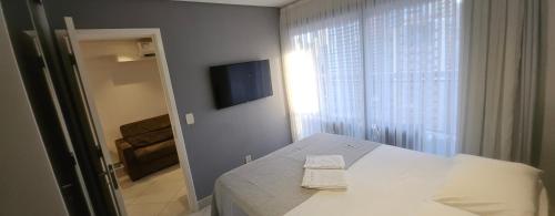 a bedroom with a bed and a window with a television at Landscape Apartment TC1502 in Fortaleza