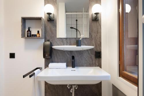 a bathroom with a white sink and a mirror at Hotel Fontana Selb in Selb