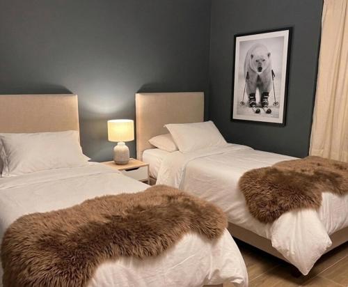 a bedroom with two beds with furry pillows on them at Increible Chalet en La Parva in Santiago