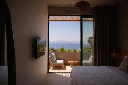 a bedroom with a view of the ocean at No908 Sunset HOTEL in Çeşme