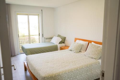 a bedroom with two beds and a window at Ofir Nature Stay in Fão
