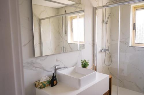 a white bathroom with a sink and a mirror at Ofir Nature Stay in Fão
