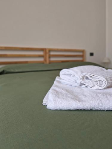 a stack of white towels sitting on a bed at Il Quadrifoglio in Frascineto