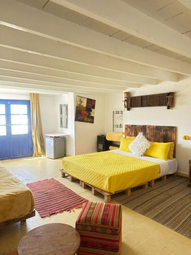 a bedroom with two beds and a yellow bedspread at Yousurf Surf House in Essaouira