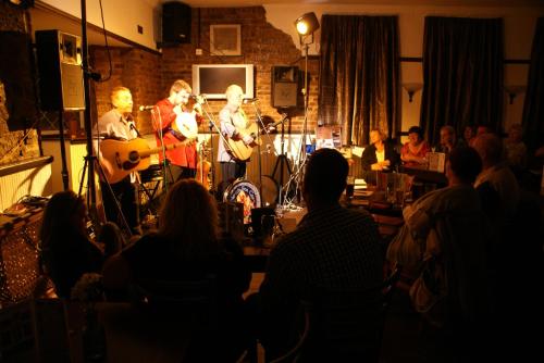 a band playing in a room with a crowd of people at The Old Ship in Newbiggin-by-the-Sea