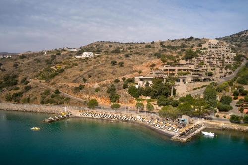 a beach with a bunch of umbrellas in the water at Domes Aulus Elounda, Adults only, Curio Collection by Hilton in Elounda