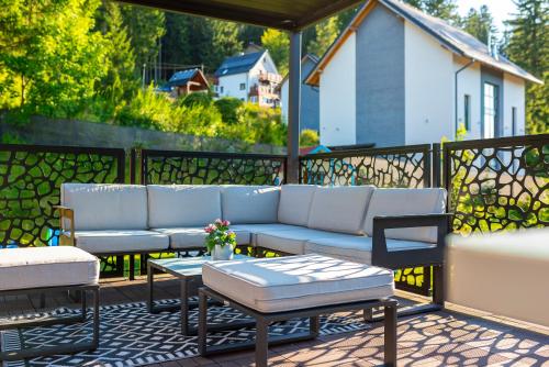 a patio with a couch and a table and chairs at Willa Szycha in Karpacz
