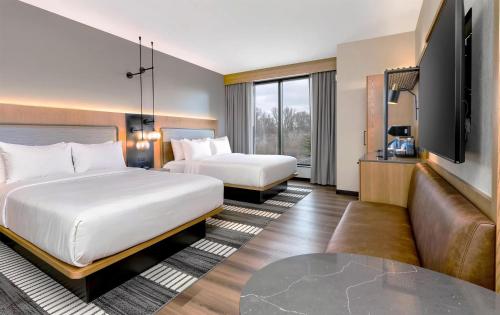 a hotel room with two beds and a flat screen tv at The Key Hotel Dubuque, Tapestry Collection By Hilton in Dubuque