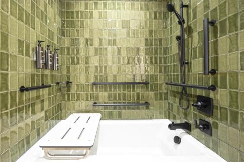 a green tiled bathroom with a sink and a shower at The Key Hotel Dubuque, Tapestry Collection By Hilton in Dubuque