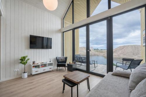 a living room with a couch and a tv at Palanga Waterhouse in Kiauleikiai