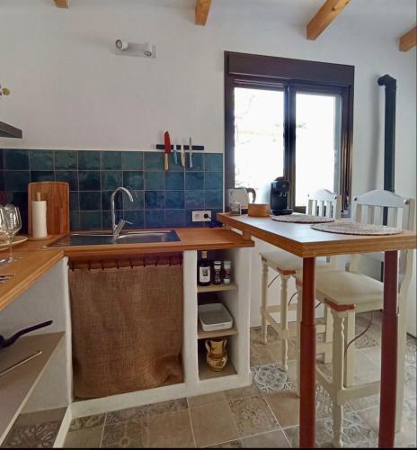 a kitchen with a sink and a counter with a table at Casa Gaïa in Borge