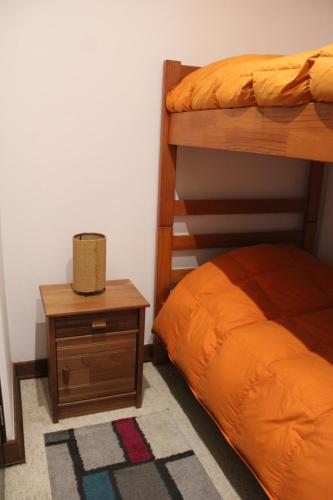 a bedroom with two bunk beds and a night stand at Pucon Parque Pinares (playa privada) in Pucón