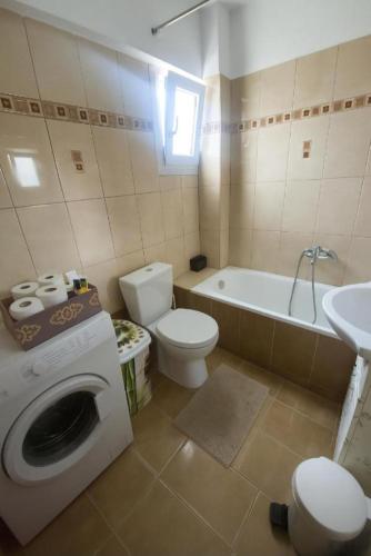 a bathroom with a washing machine and a toilet at Epanomi Family Apartments in Epanomi