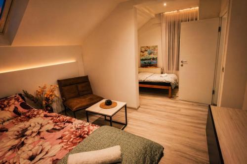 a bedroom with a bed and a chair and a table at Danin's Home in Tuzla