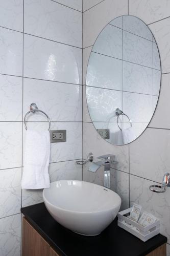 a white bathroom with a sink and a mirror at Andari Hoteles in Arequipa