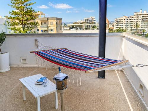 a hammock on top of a balcony with a table at City Penthouse in Larnaca