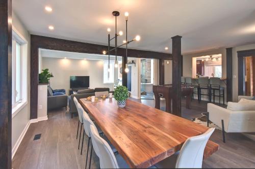 a dining room and living room with a wooden table and chairs at SPA private pond and beach volleyball in Lac-Superieur