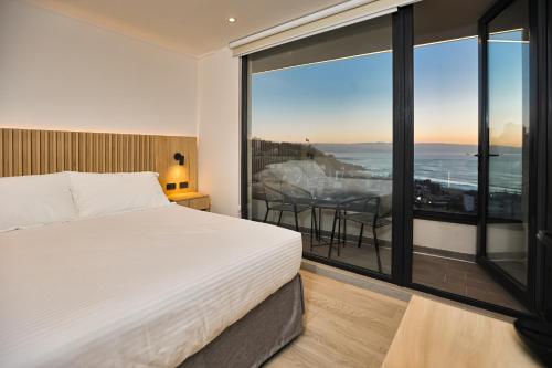 a bedroom with a bed and a view of the ocean at Arka Hotel in Viña del Mar