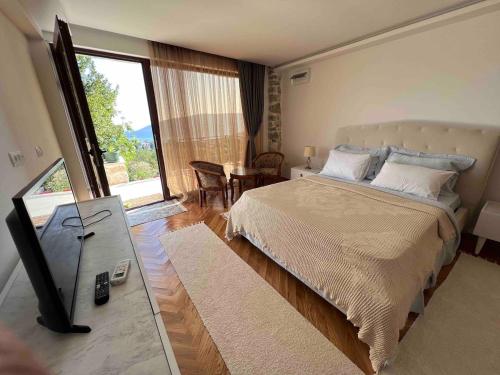 a bedroom with a bed and a table and a window at Vila Bella Vista in Herceg-Novi