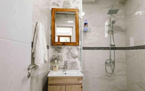 a bathroom with a sink and a mirror and a shower at Vila Bella Vista in Herceg-Novi