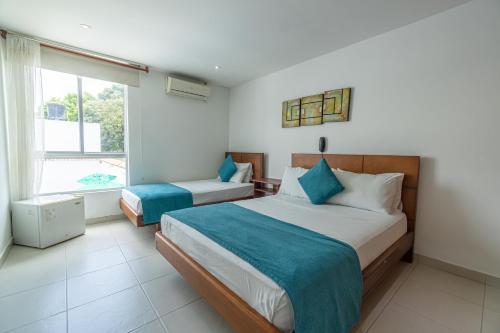 a bedroom with two beds and a window at Casa Serena Hotel Boutique in Melgar